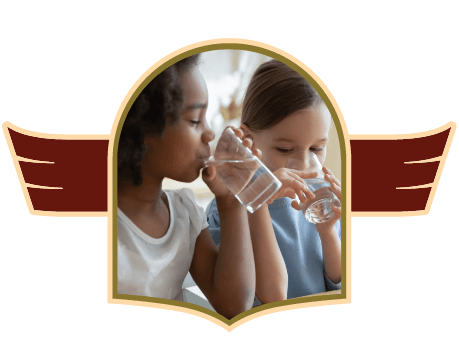 Two young girls drinking clean water from a glass